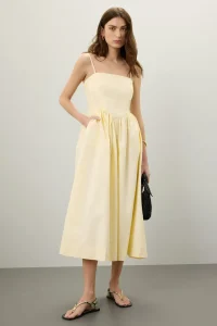 Soft yellow ruffled dress styled for warm weather