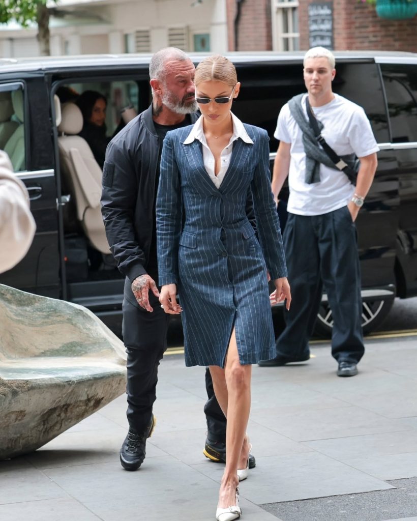 Bella Hadid in a tailored striped blazer dress paired with slingback pumps and narrow sunglasses on the streets of London