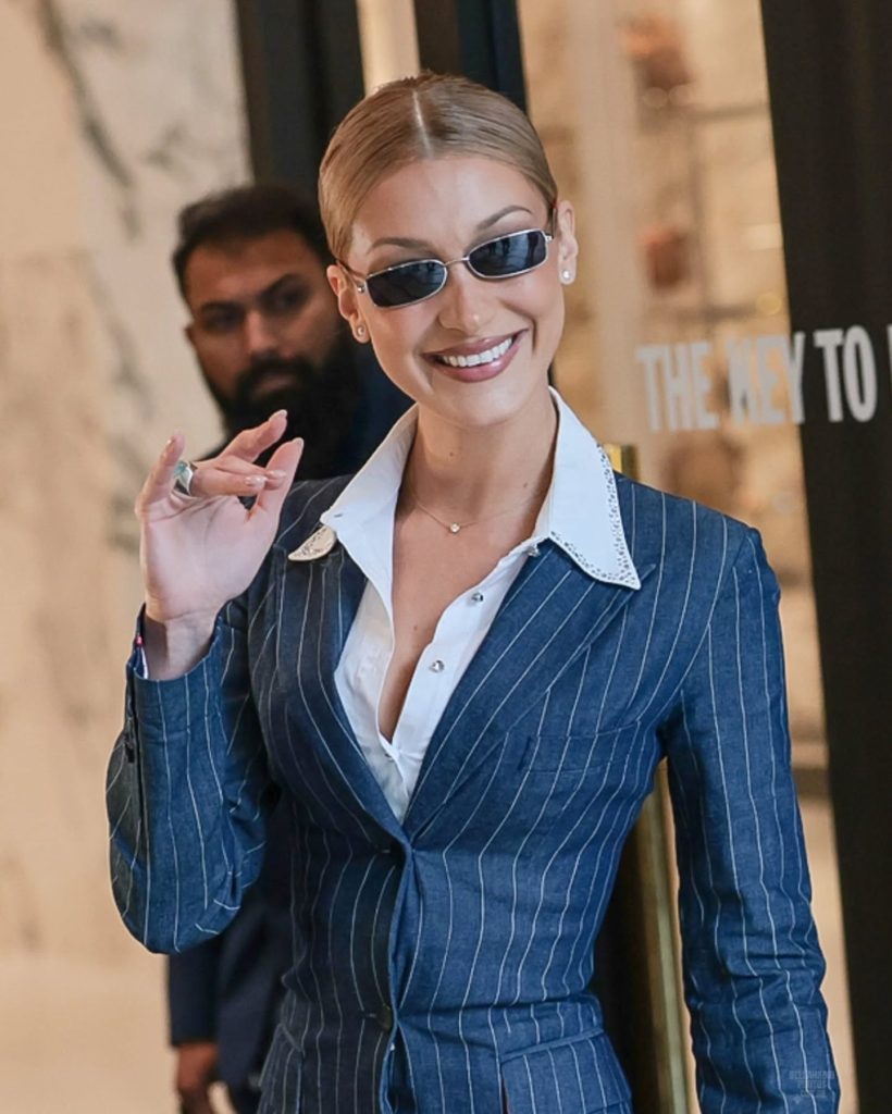 Bella Hadid in a tailored striped blazer dress paired with slingback pumps and narrow sunglasses on the streets of London
