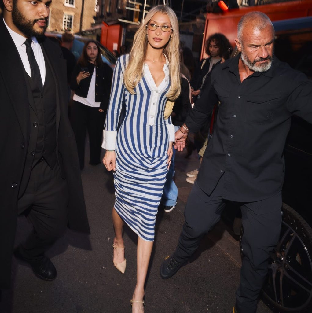 Bella Hadid wearing a blue and white striped vintage dress and gold sunglasses in London